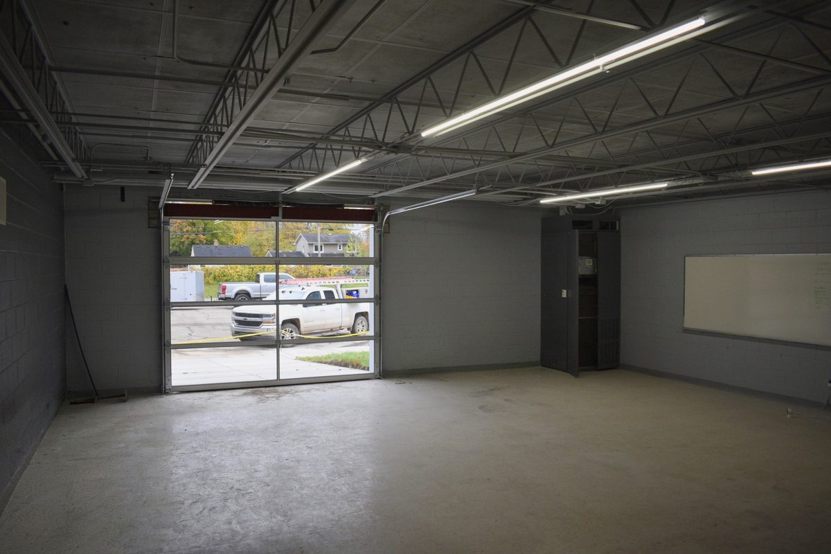 An empty garage suite with its new glass overhead door installed, looking out to the lot.